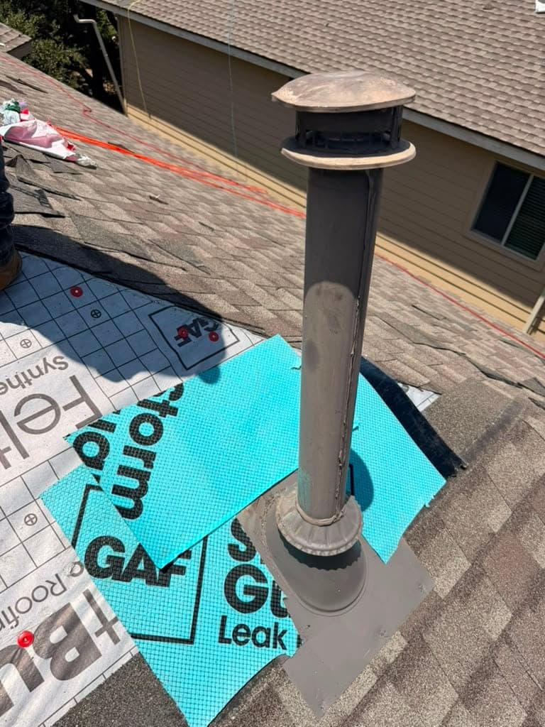 Vent pipe collar set into StormGuard leak barrier before shingles are run around it