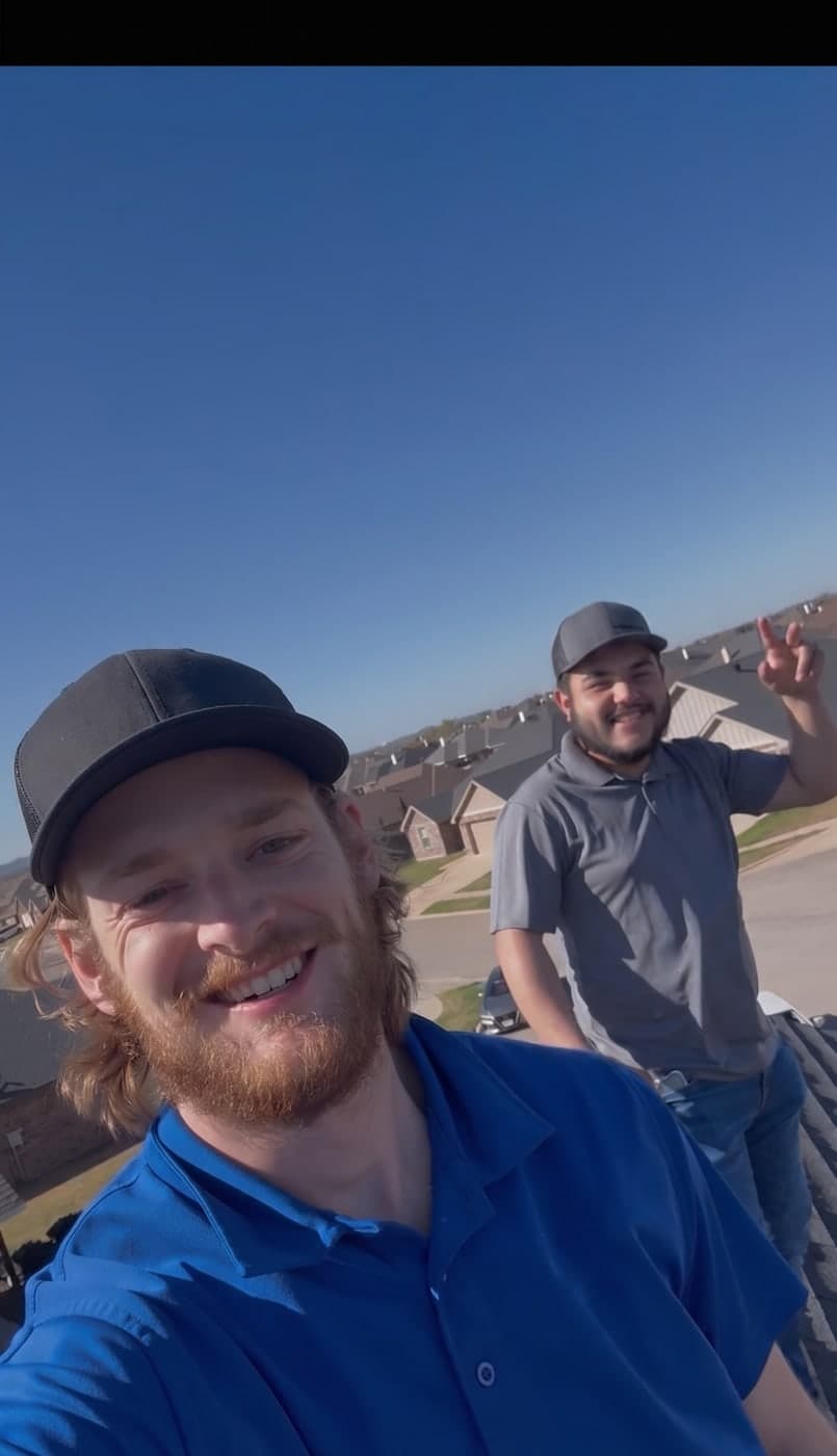 Two Stormforged crew members on a job, one in a blue company polo